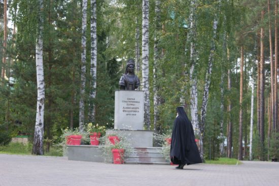 Moine orthodoxe en prière devant la statue de la tsarine Alexandra Feodorovna à Ekaterinburg