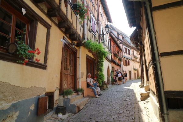 « Au village d'Eguisheim. Quel plaisir de retrouver l'Alsace et les maisons à colombages en été ! Jean et Marie-Ange - assis à gauche -m'attendaient un peu plus loin. Ils étaient un peu fatigués à cause de la chaleur. » 