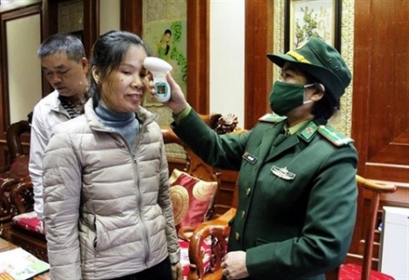 Vérification de la température corporelle d'une passagère à la porte frontière de Mong Cai, province de Quang Ninh